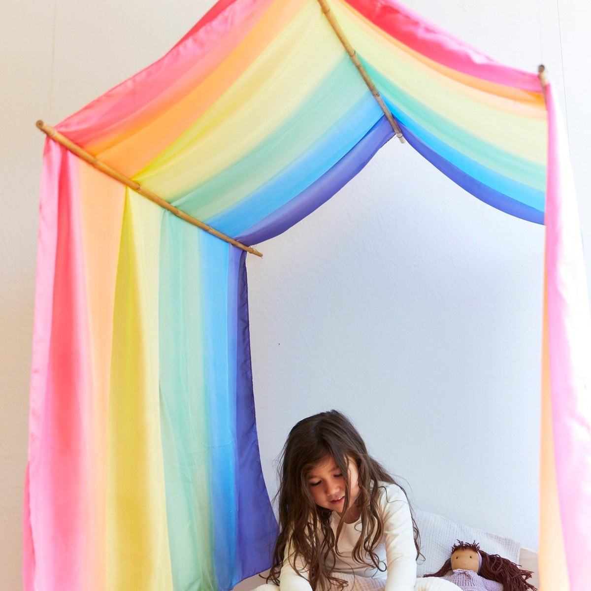 A child sitting inside a colorful canopy sarasilk